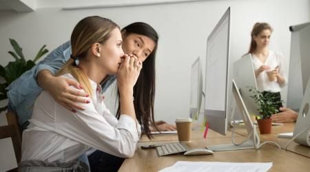 Eine Mitarbeiterin mit einer persönlichen Krise wird an Ihrem Schreibtisch von einer Kollegin beruhigt
